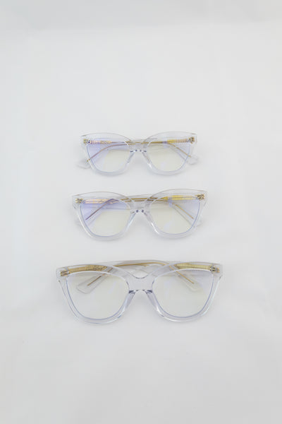 Three women's blue light glasses with clear lenses and clear frames with gold accents.