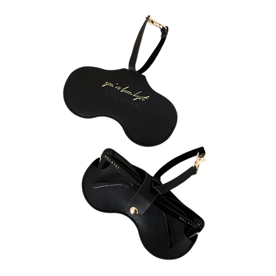 Two views of the black Sol Kyst Kyst Klip, one with 'you’ve been kyst' gold lettering and another holding sunglasses.