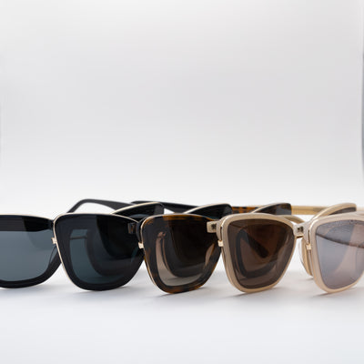 A row of cat eye sunglasses in black, tortoise, and beige frames with gradient lenses, displayed side-by-side on a white background.